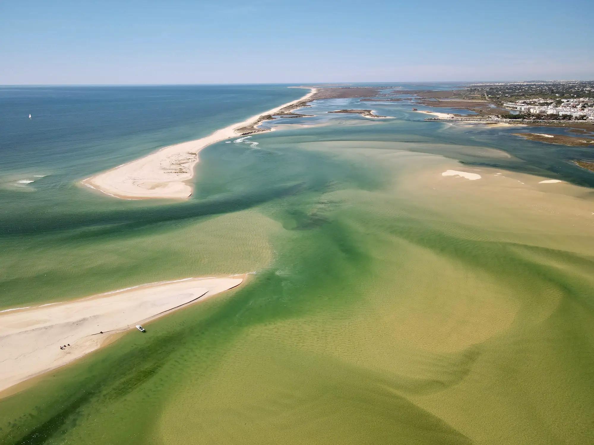 Aerial view of the Ria Formosa near Fuseta: white sandbanks, shallow green channels and the barrier island against the Atlantic.